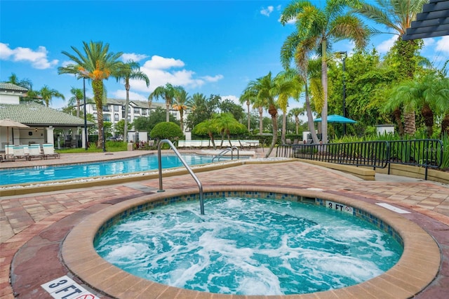 view of swimming pool featuring a patio and a hot tub