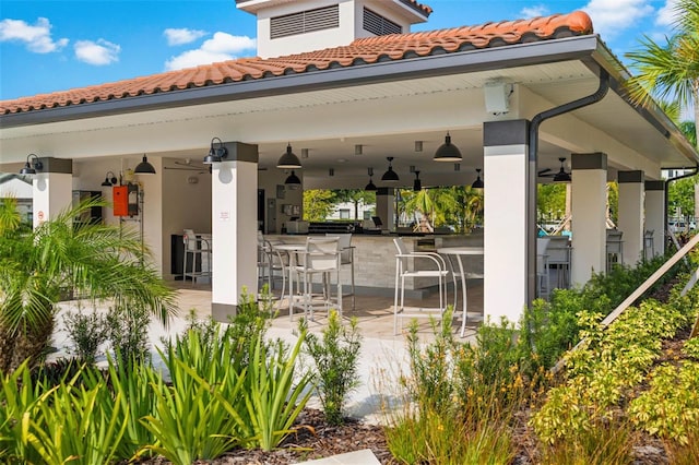 view of patio featuring an outdoor bar and ceiling fan