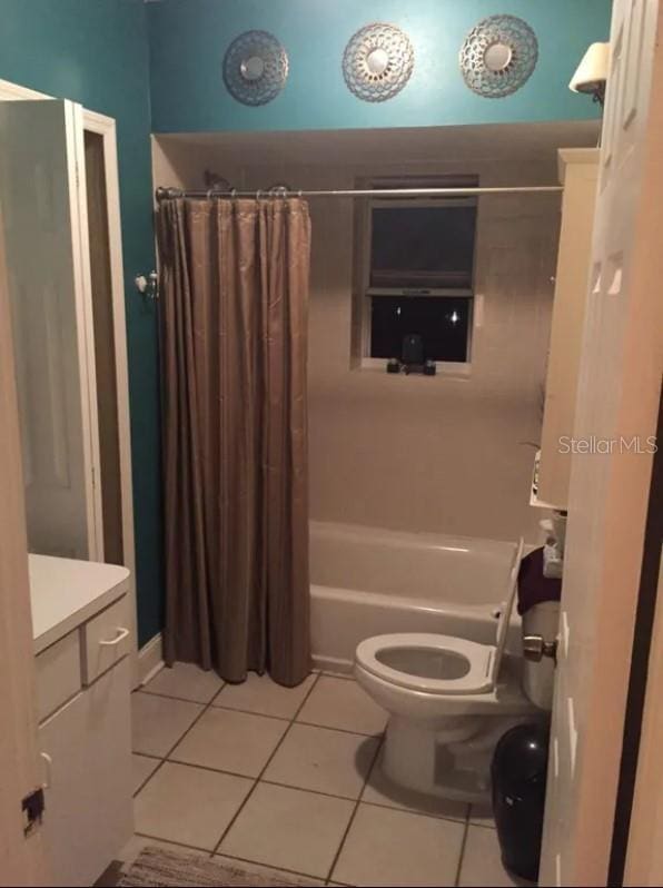 full bathroom featuring shower / tub combo, vanity, tile floors, and toilet