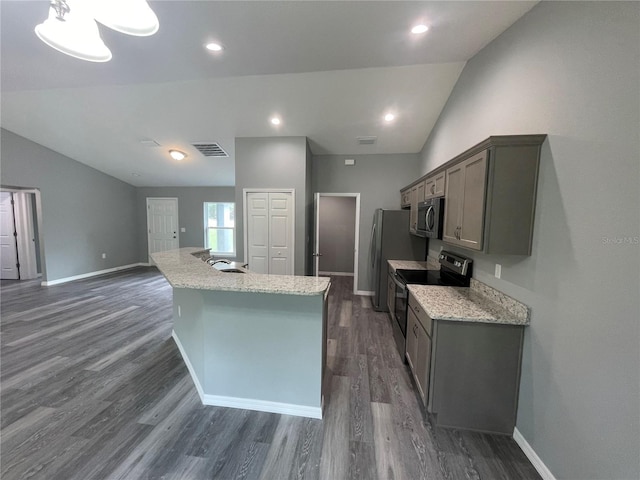 kitchen with lofted ceiling, dark hardwood / wood-style flooring, gray cabinets, and appliances with stainless steel finishes