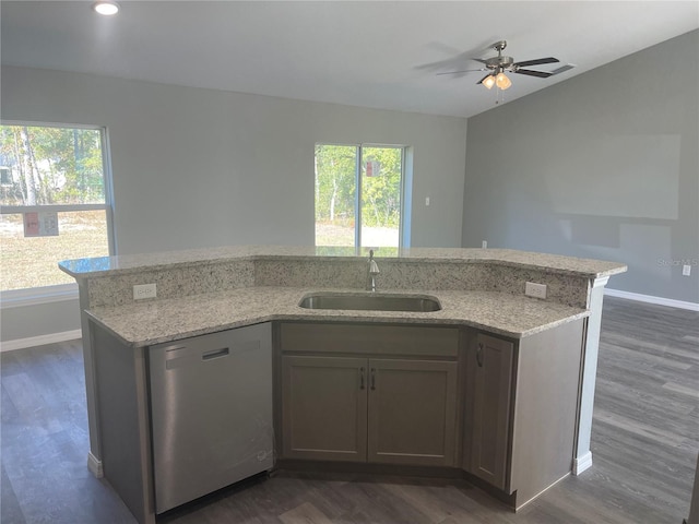 kitchen featuring light stone counters, dark wood-type flooring, dishwasher, and sink