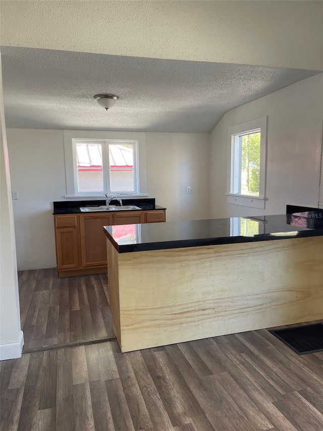 kitchen featuring dark wood-type flooring, a textured ceiling, and sink