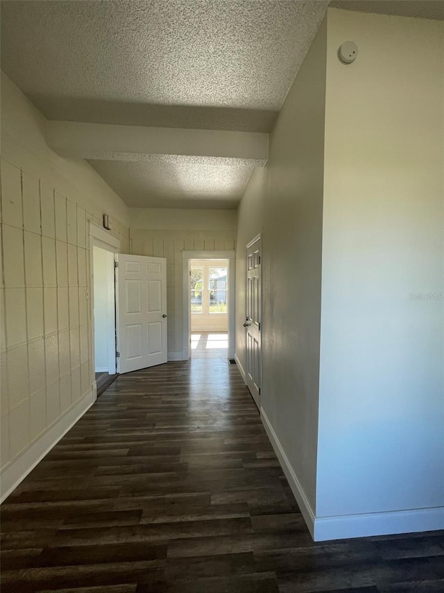 hall featuring a textured ceiling and dark wood-type flooring