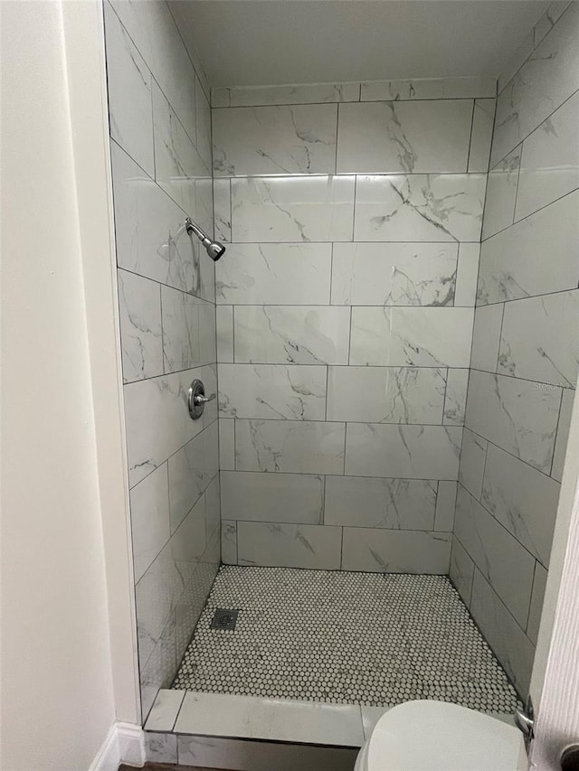 bathroom with toilet and tiled shower