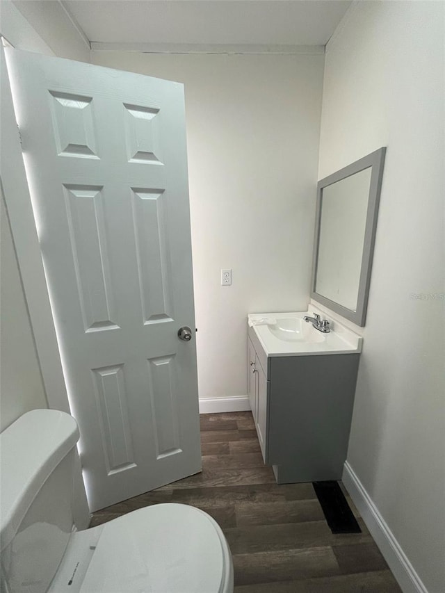 bathroom featuring toilet, vanity, and hardwood / wood-style flooring