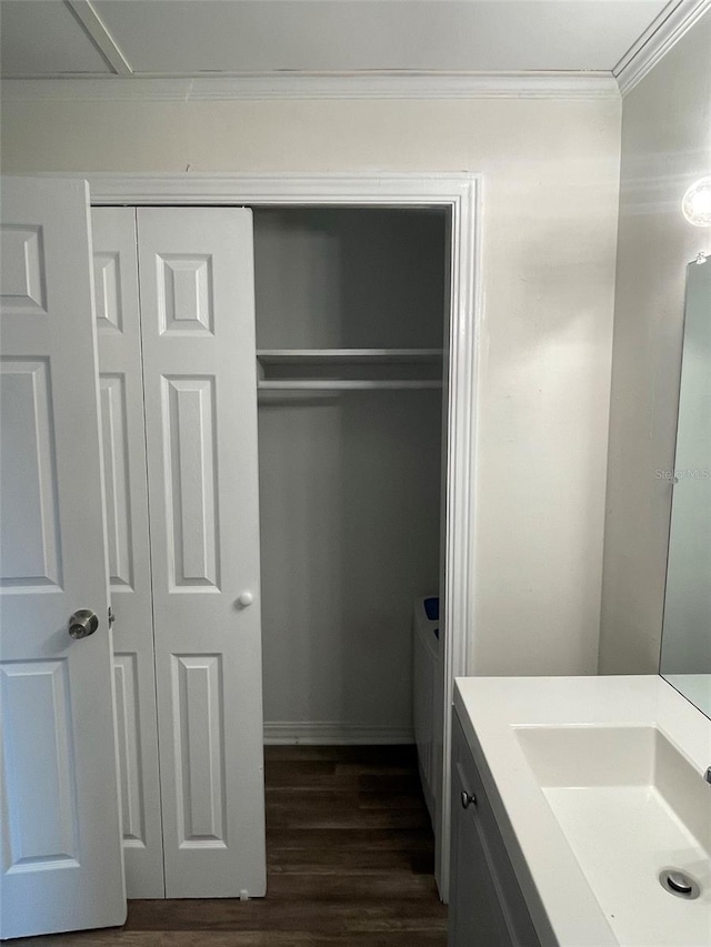 bathroom featuring crown molding, wood-type flooring, and vanity