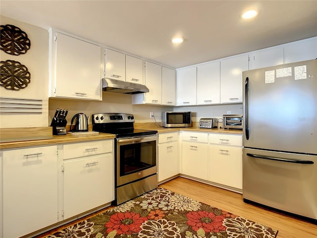 kitchen with stainless steel appliances, white cabinetry, and light hardwood / wood-style flooring