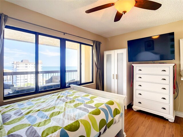 1513 Ocean Shore Blvd Unit 9E, Ormond Beach, FL 32176 - bedroom with access to outside, wood finished floors, a textured ceiling, and ceiling fan