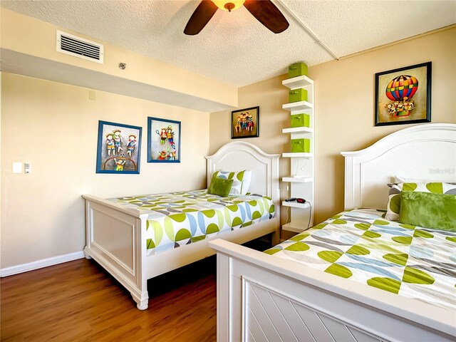 1513 Ocean Shore Blvd Unit 9E, Ormond Beach, FL 32176 - bedroom featuring wood finished floors, visible vents, baseboards, a textured ceiling, and ceiling fan