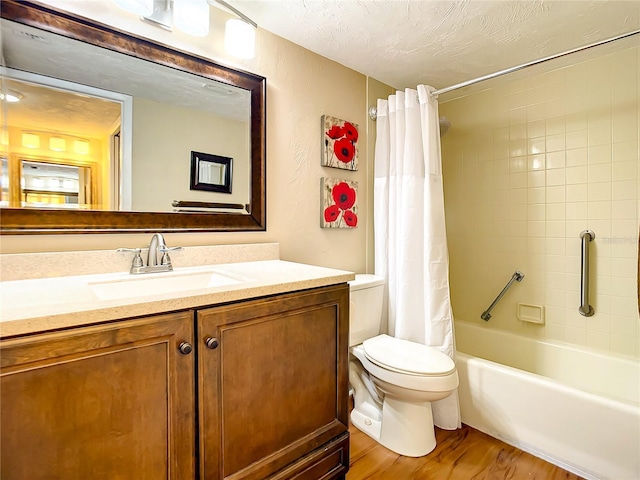 1513 Ocean Shore Blvd Unit 9E, Ormond Beach, FL 32176 - full bathroom featuring wood finished floors, a textured ceiling, vanity, shower / bathtub combination with curtain, and toilet