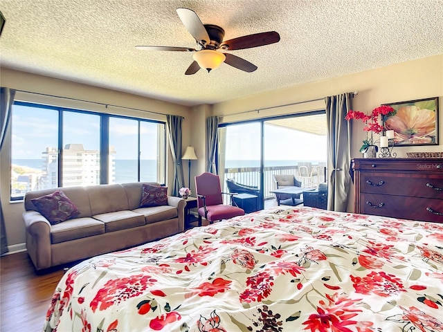 1513 Ocean Shore Blvd Unit 9E, Ormond Beach, FL 32176 - bedroom with a textured ceiling, wood finished floors, access to exterior, and ceiling fan