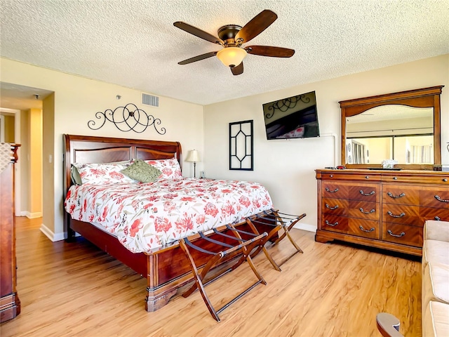 1513 Ocean Shore Blvd Unit 9E, Ormond Beach, FL 32176 - bedroom featuring visible vents, a ceiling fan, light wood-type flooring, baseboards, and a textured ceiling