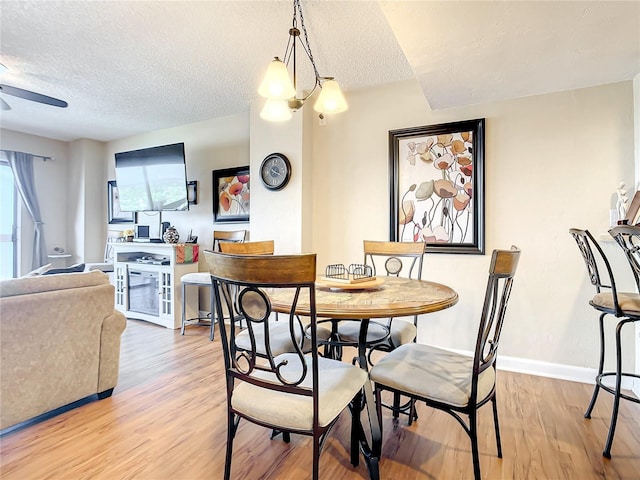1513 Ocean Shore Blvd Unit 9E, Ormond Beach, FL 32176 - dining room featuring light wood-style flooring, baseboards, a textured ceiling, and a ceiling fan