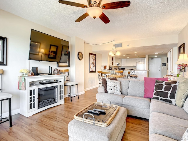 1513 Ocean Shore Blvd Unit 9E, Ormond Beach, FL 32176 - living area featuring ceiling fan, wood finished floors, visible vents, and a textured ceiling