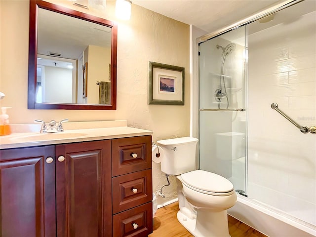1513 Ocean Shore Blvd Unit 9E, Ormond Beach, FL 32176 - bathroom featuring a shower stall, toilet, vanity, and wood finished floors
