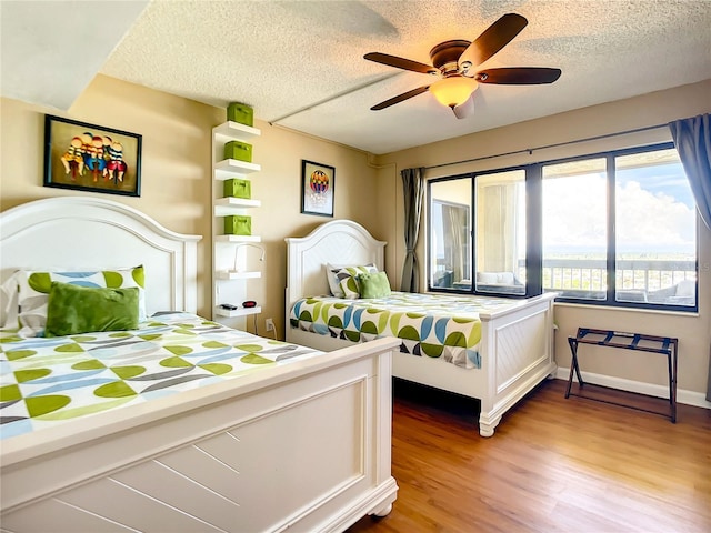 1513 Ocean Shore Blvd Unit 9E, Ormond Beach, FL 32176 - bedroom with light wood-style flooring, a textured ceiling, and a ceiling fan