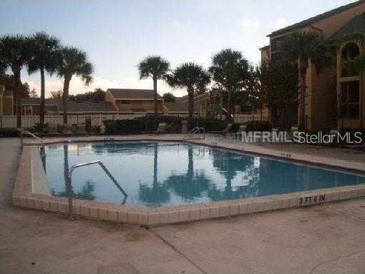 pool at dusk with a patio