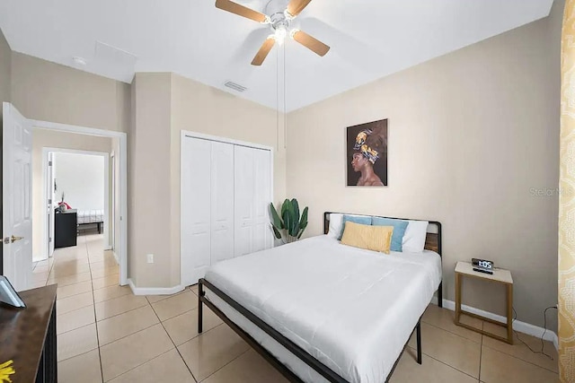 tiled bedroom featuring ceiling fan and a closet