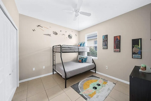 tiled bedroom with ceiling fan and a closet