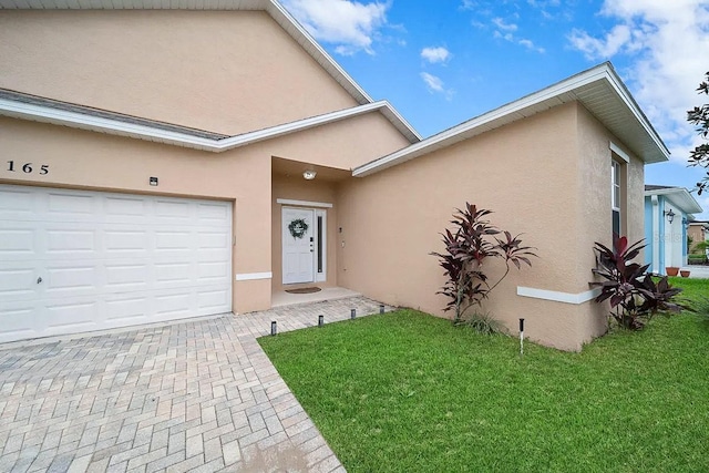 doorway to property featuring a garage and a yard