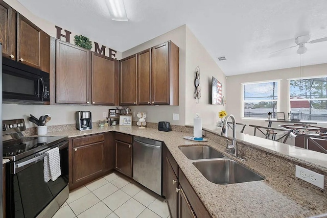 kitchen with light stone countertops, stainless steel appliances, dark brown cabinetry, and sink