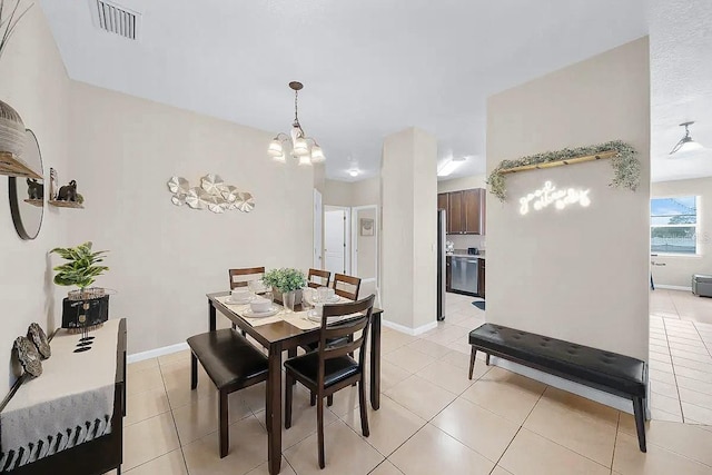 dining room featuring light tile patterned flooring and a chandelier