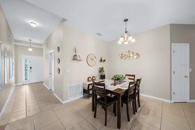 dining area with light tile patterned floors and an inviting chandelier