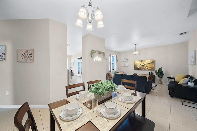 dining space featuring light tile patterned flooring and an inviting chandelier