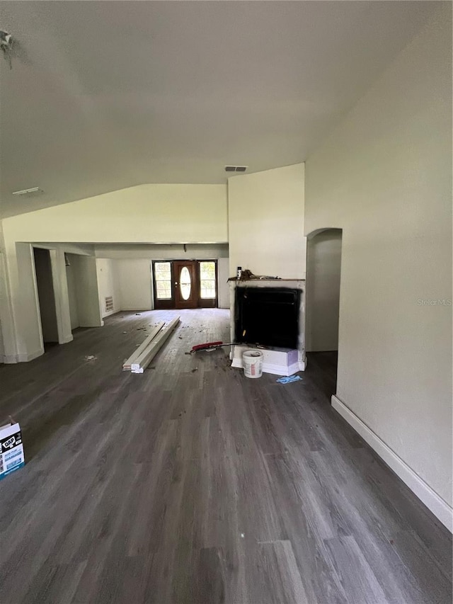 unfurnished living room with dark hardwood / wood-style floors and vaulted ceiling