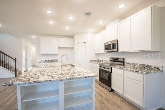 kitchen with light stone countertops, wood tiled floor, recessed lighting, a sink, and stainless steel appliances