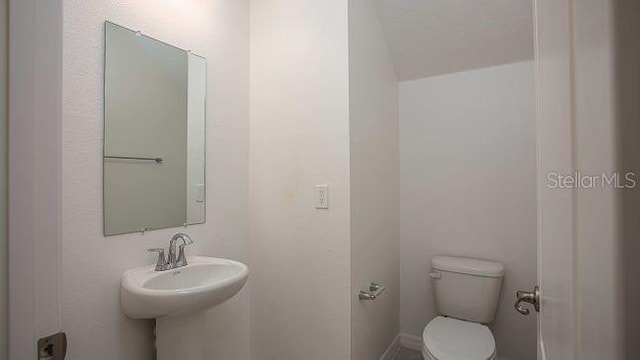 half bath featuring a sink and toilet