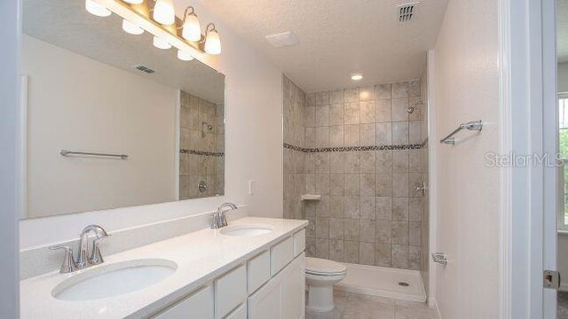 full bath featuring double vanity, visible vents, and a sink