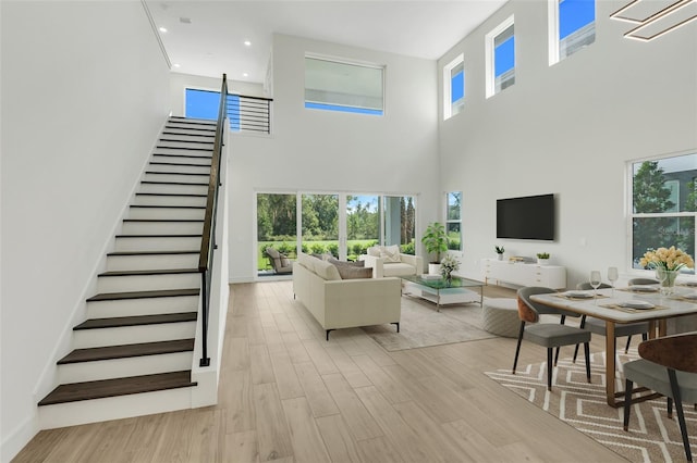 living room with light hardwood / wood-style flooring and a high ceiling