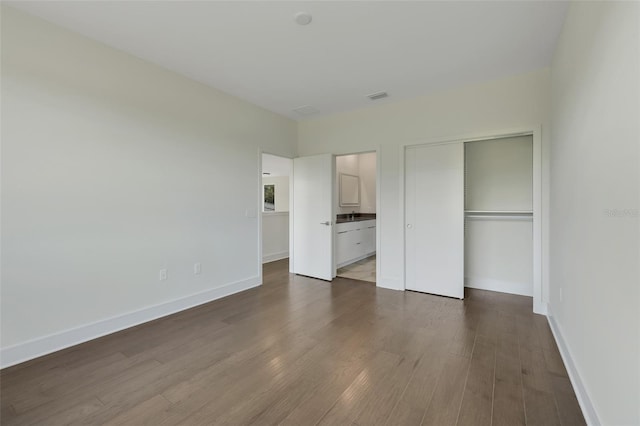 unfurnished bedroom featuring dark wood-type flooring and a closet