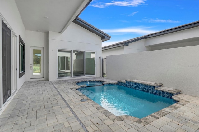 view of swimming pool featuring a patio area and an in ground hot tub