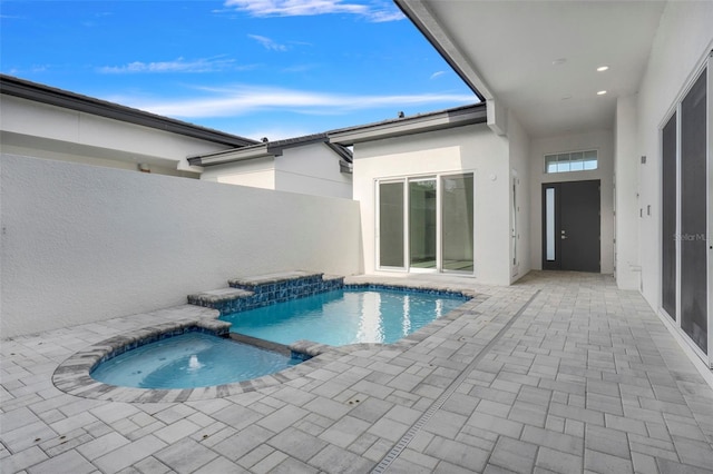 view of swimming pool featuring an in ground hot tub and a patio area