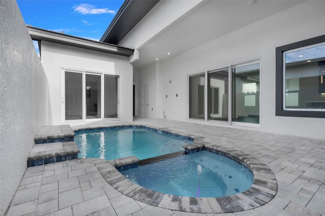 view of pool with an in ground hot tub and a patio