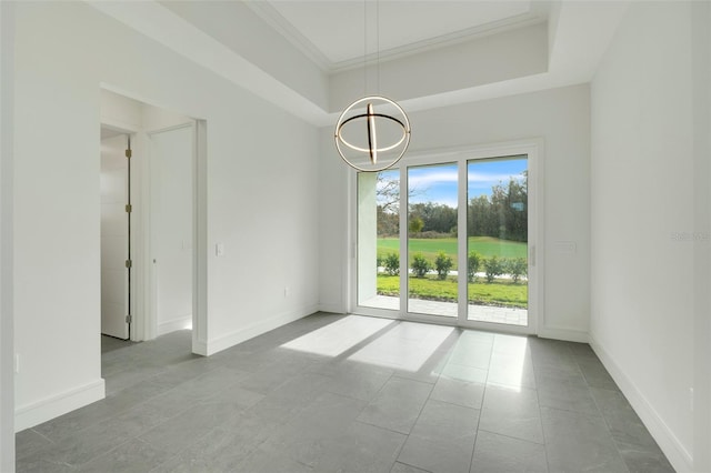 empty room with a notable chandelier, a tray ceiling, and ornamental molding