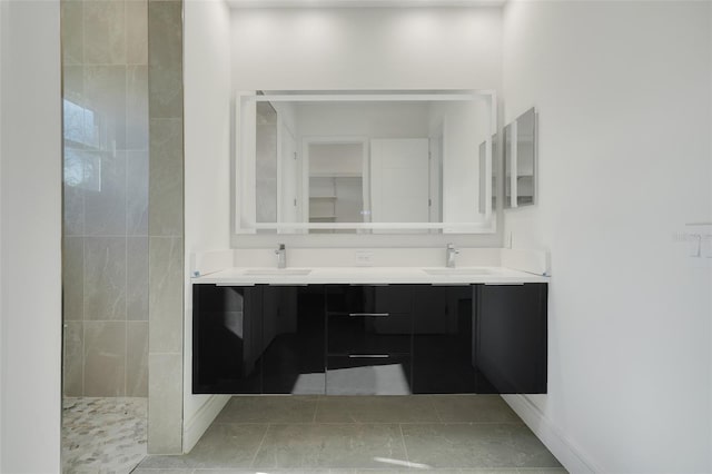 bathroom with walk in shower, vanity, and tile patterned flooring