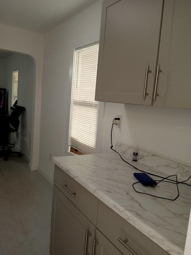 kitchen featuring light stone counters and a healthy amount of sunlight