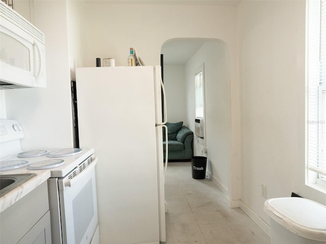 kitchen featuring light tile flooring and white appliances