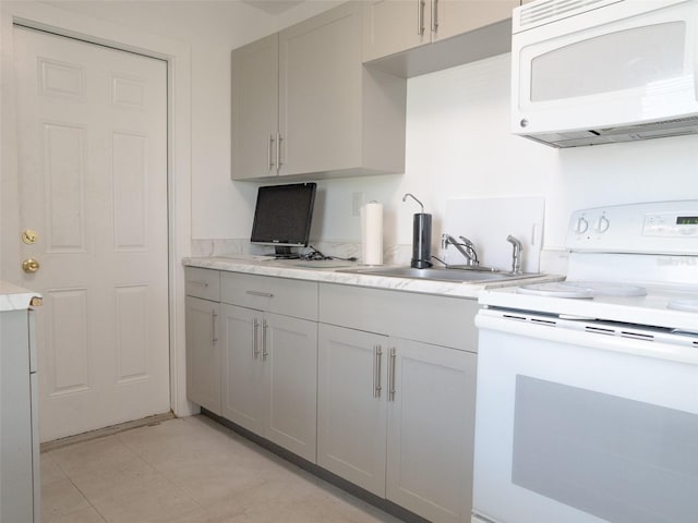 kitchen with white appliances, gray cabinets, and light tile floors