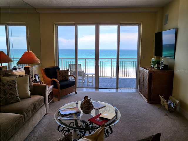 carpeted living room featuring a water view and a wealth of natural light