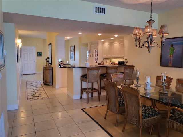 tiled dining space featuring an inviting chandelier