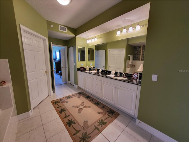 bathroom with a bath, tile flooring, and dual bowl vanity