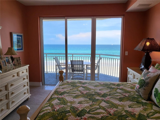 bedroom with a water view, access to exterior, and light tile floors