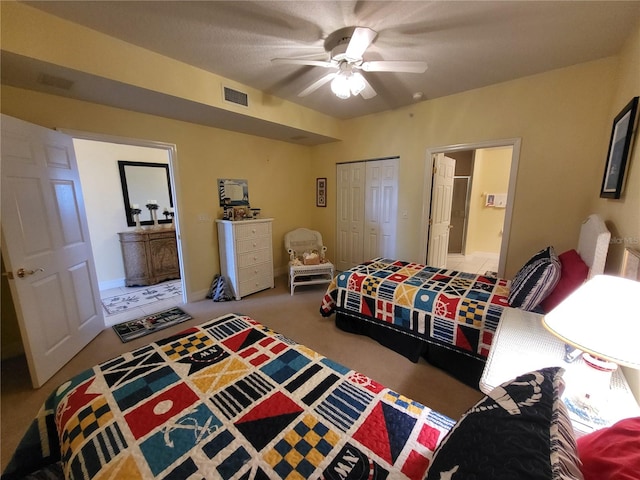 bedroom featuring light carpet, connected bathroom, a closet, and ceiling fan