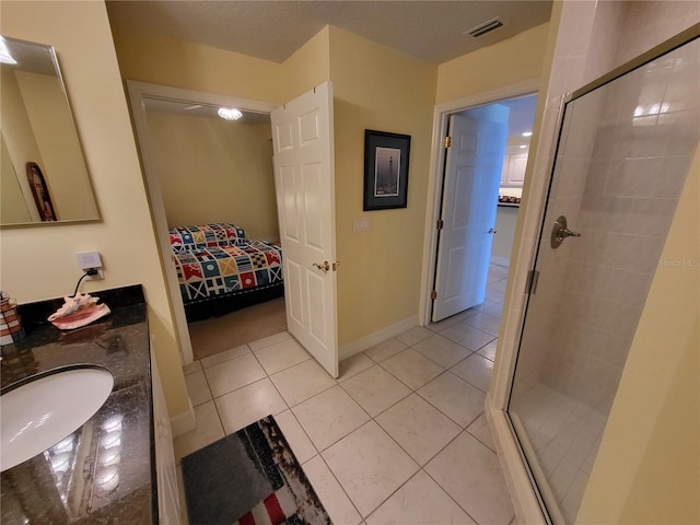 bathroom with double sink, walk in shower, tile floors, and large vanity