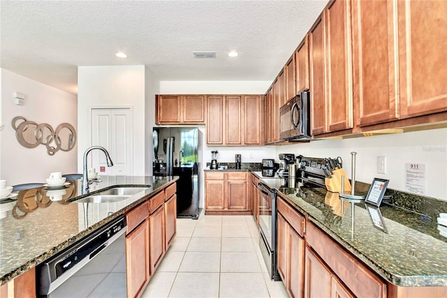 kitchen featuring dark stone countertops, sink, light tile floors, and black appliances