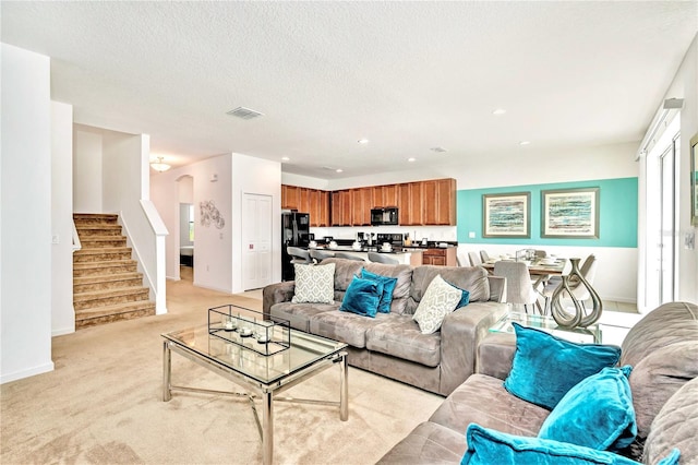 carpeted living room featuring a textured ceiling